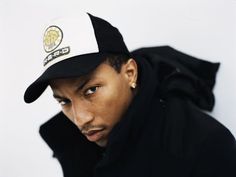 a young man wearing a black and white hat with the cap on his head is looking at the camera