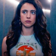 a woman standing in front of a mirror wearing a tank top with the words beauty on it