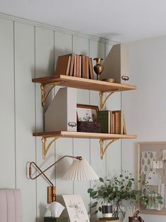 a desk with some books on top of it and a lamp next to the desk