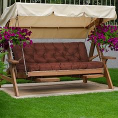 a wooden swing bed with flowers hanging from it