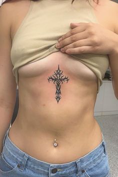 a woman with a cross tattoo on her stomach