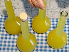 three yellow vases sitting on top of a blue and white checkered table cloth