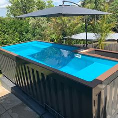 an above ground swimming pool in the middle of a backyard with umbrellas over it