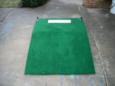 a green area rug sitting on the sidewalk