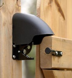 a close up of a wooden fence with a black helmet mounted on it's side