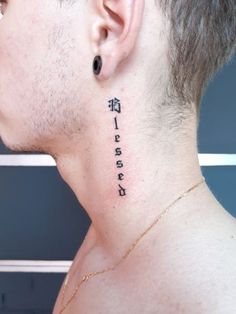 the back of a man's neck with chinese characters tattooed on his left side