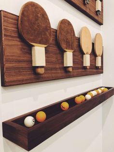 three wooden paddles mounted to the wall with balls in them and on top of each other