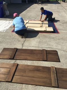 two men working on some wood planks with the words install interior doors as focal points of rustic interior design, barn doors can bring interest and a sense of history to a space