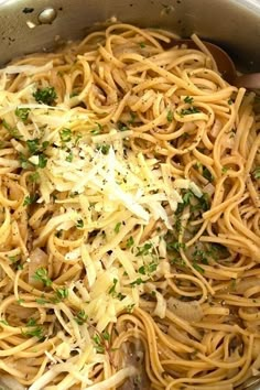 a pot full of pasta with parmesan cheese and herbs on top, ready to be cooked