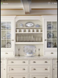 a white china cabinet with dishes on it