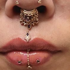 a woman's nose with piercings on it