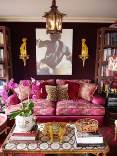 a living room filled with furniture and a painting on the wall above it's coffee table