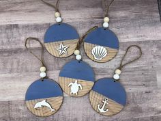 four wooden ornaments with marine themed designs on them