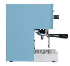 an espresso machine sitting on top of a white counter next to a blue wall