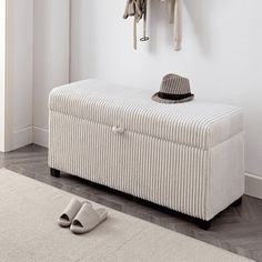 a white bench sitting next to a coat rack with hats and shoes on top of it