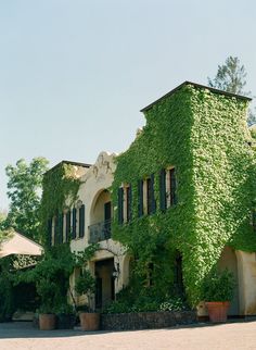 an old building covered in vines and plants