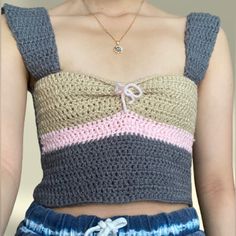 a woman wearing a crochet top and shorts with her hands in her pockets