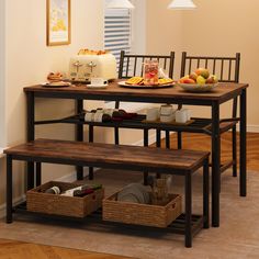 the table is set up with two benches and plates on it, along with baskets full of food