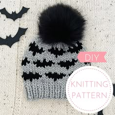 a knitted hat with a black and white pattern on it, next to bats