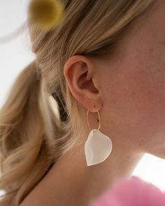 White porcelain earrings in the shape of flower petals. Minimalistic and perfect to wear - porcelain earrings are very lightweight! You will barely notice that you have them in your ears. Perfect for everyday wear and going out, purchased frequently by brides. Handmade in a small ceramic studio in Warsaw, Poland. Each piece is unique and may vary slightly. Rings made of antiallergic gold plated stainless steel. SIZE AND MATERIAL Measures: width 3.1 cm, lenght (with a ring) about 5.6 cm Weight: about 3 g Materials: pigmented porcelain, gold plated stainelss steel rings, antiallergic. OTHER AVAILABLE COLOURS Baby blue:  Pink: OTHER ITEMS FROM THIS COLLECTION In my shop you will find a collection of porcelain flower petal jewelry, it consist also of pendants and bigger earrings in different c Flower Petal Jewelry, Minimalist Jewellery, Porcelain Earrings, Earrings Big, Jewelry Minimalist, Jewellery Gold, Porcelain Flowers, Flower Petal, Ceramic Studio