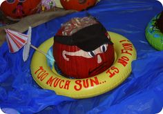 an inflatable pumpkin sitting on top of a blue tarp covered ground next to other decorations