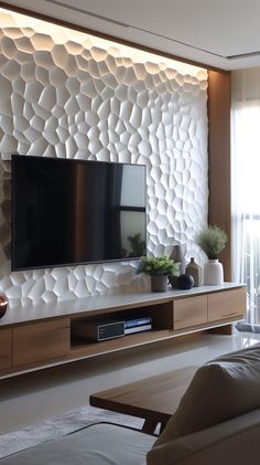 a living room with a flat screen tv mounted on the wall next to a couch