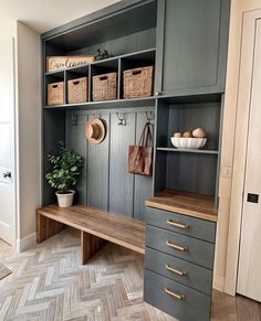 a wooden bench sitting in front of a gray bookcase filled with baskets and other items