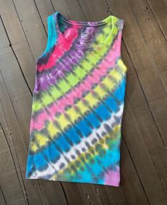 This awesome tie dye tank is the cool and edgy and super unique! Bright and bold liquid fiber reactive dyes were applied in a diagonal pattern and finished with black  detailing. This tie dye is truly special and stands out from the rest. Girls size 6/6X true to size.     Each piece is dyed meticulously by hand with fiber reactive dyes and takes a full 24 hours to complete. The color is permanent and should last the lifespan of the garment. Every item comes with a Dye Happy Boutique tag and is w Spring Hand Dyed Tie Dye Tank Top, Cotton Tie-dye Tank Top For Festival, Playful Cheap Tie-dye Tops, Cheap Playful Tie-dye Tops, Spring Hand-dyed Tie Dye Tank Top, Custom Sticker, Tie Dye Tank Top, Tanktop Girl, Graphic Tank Tops