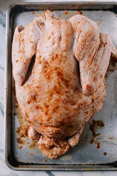 a raw chicken sitting on top of a metal pan