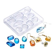 an assortment of earrings and earring sets in a plastic container on a white background