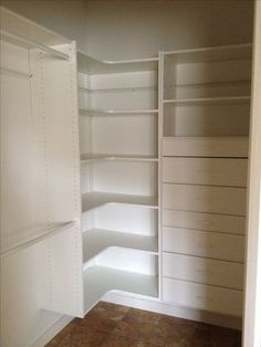 an empty closet with white shelving and tile flooring in the middle of it