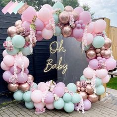 a baby shower with balloons and streamers in the shape of a heart, on display outside