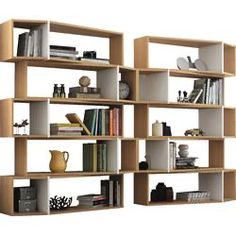 a book shelf filled with lots of books on top of each other next to a vase