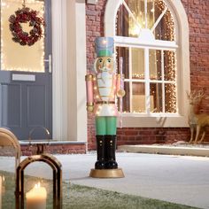 a large nutcracker standing in front of a house with christmas lights on the windows