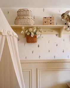 there is a teddy bear on the shelf next to flowers and a stuffed animal in a basket