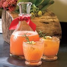 three glasses with drinks in them sitting on a counter