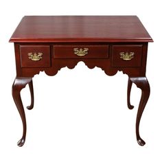 a wooden desk with two drawers on one side and an ornate design on the other