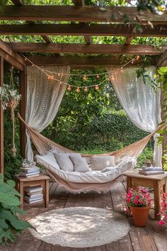 a hammock is set up in the middle of a wooden deck surrounded by greenery