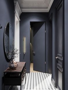 a hallway with a checkered floor and walls painted in dark blue, black and white