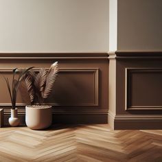 a potted plant sitting on top of a wooden floor next to two vases