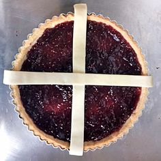 a pie with a white ribbon around it sitting on top of a metal countertop