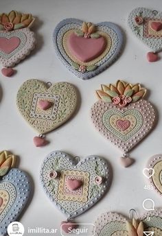 some heart shaped cookies are arranged on a white table with pink and blue decorations in the shape of hearts