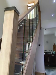 a stair case with glass railing and wood handrail