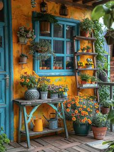 an outdoor area with potted plants and flowers in front of a yellow building,