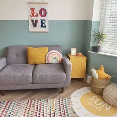 a living room with a gray couch and colorful rugs on the wooden flooring