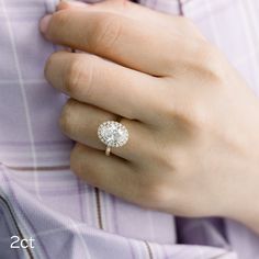 a close up of a person's hand wearing a diamond ring