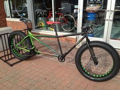 a green and black bike parked in front of a store