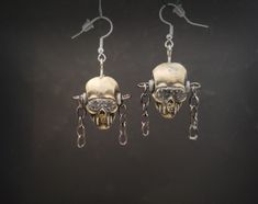 "This is a pair of earrings designed after Megadeth's iconic skull mascot, Vic Rattlehead. ( I did'nt know that was his name until recently).  They were sculpted, cast in resin, and painted by hand and set with chains  hanging from the sides.  The top eyelets are screwed in so they can be turned to position.  Skull is  5/8\" W x 1\"H x 3/4\"D, note the third pic for size reference." Edgy Nickel-free Skull Earrings, Nickel-free Skull Earrings In Punk Style, Handmade Alternative Style Earrings For Gift, Handmade Metal Skull Earrings, Skull Shaped Metal Earrings, Vic Rattlehead, Wire Wrap Jewelry Designs, Resin Earrings, Jewelry Inspo