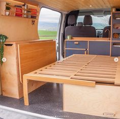 the interior of a van with wooden furniture