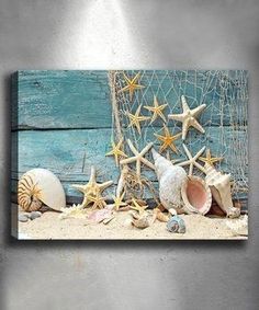 seashells and starfish on the beach near a fishing net with blue wood background